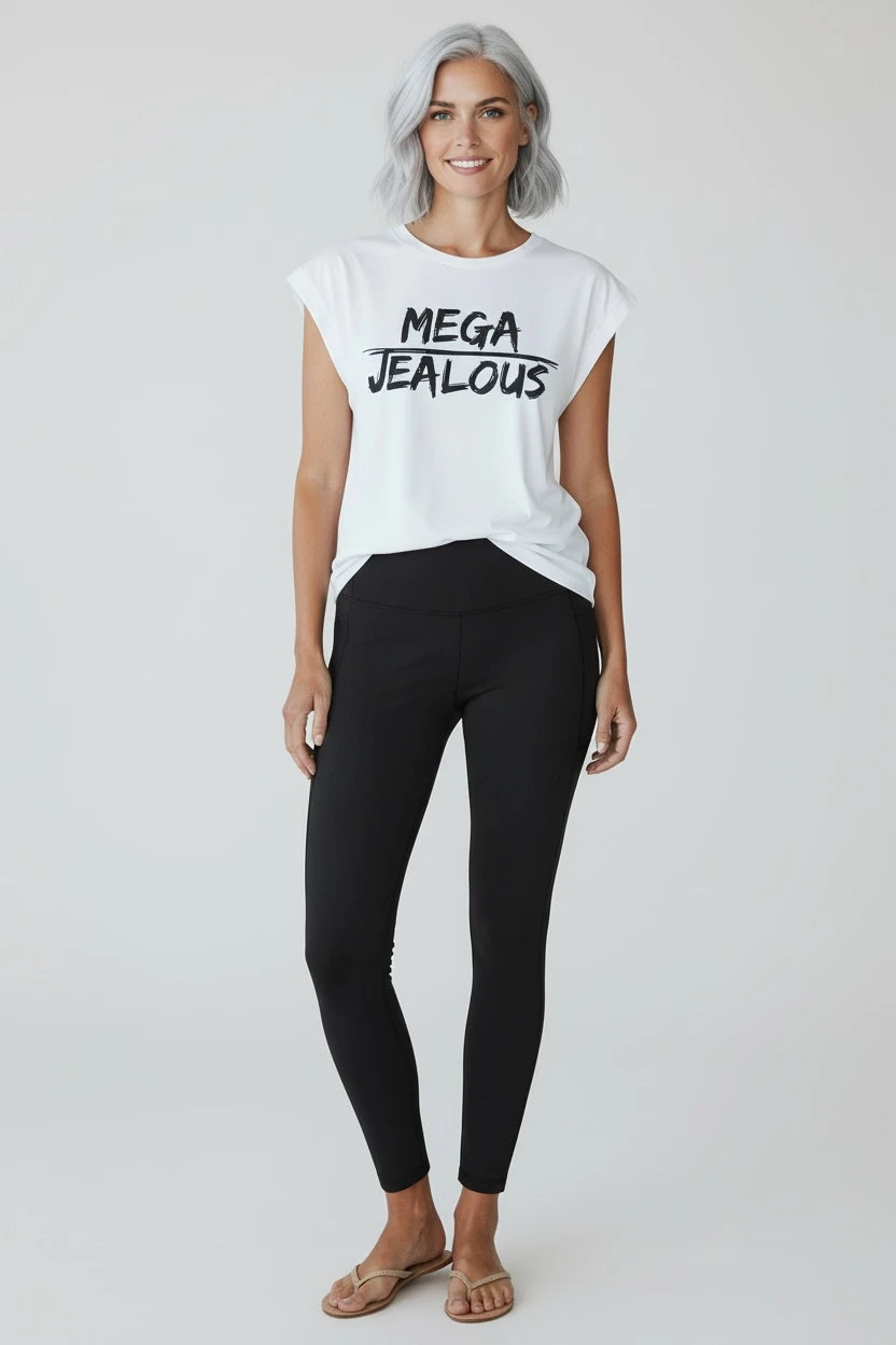 Woman wearing a white muscle tee shirt with MEGA JEALOUS design and black leggings