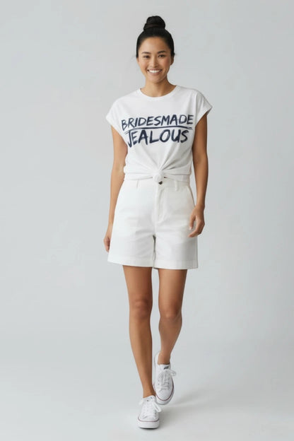 Woman in Jealous Tee white t-shirt with BRIDESMADE design  by JealousTee and white shorts