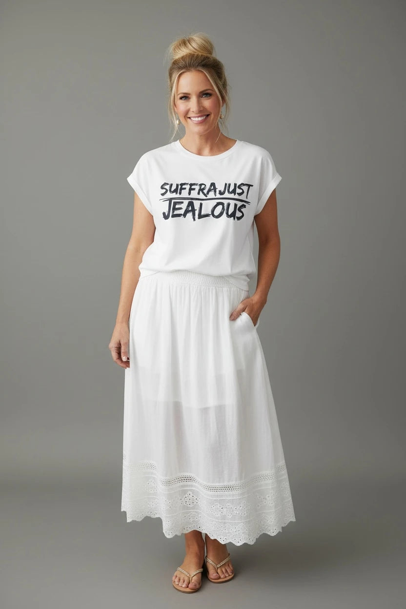 Woman wearing a white sleeveless tee with SUFFRAJUST JEALOUS design and a white skirt