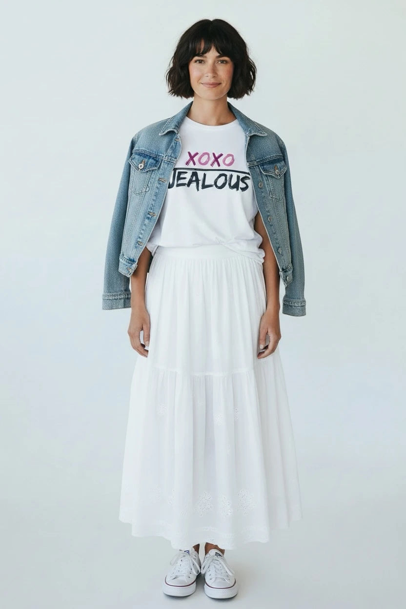 Person wearing Jealous Tee XOXO women's muscle tee with denim jacket, and white skirt